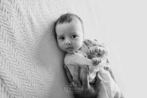 A father holds one of his newborn twins in his hands