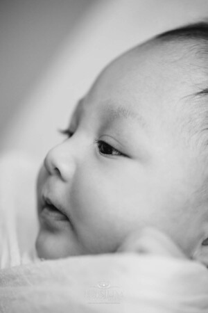 The profile face of a newborn baby boy in black and white