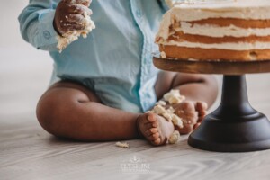 Messy baby feet covered in icing from a studio cake smash session