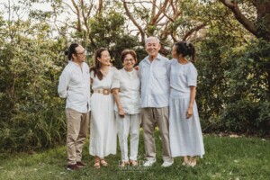 Parents stand with their adult children cuddled around them