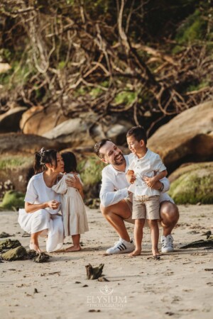 Parents play in the sand with their children at sunset