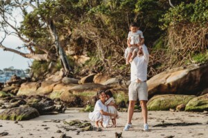 Parents play in the sand with their children at sunset