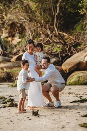 Parents play in the sand with their children at sunset