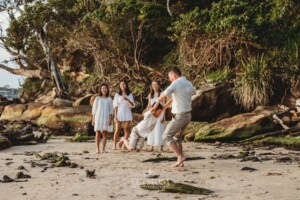 Parents play in the sand with their children at sunset