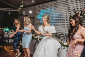 A bride dances with wedding guests during the reception party