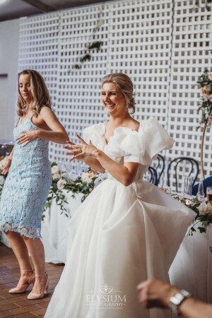 A bride dances with wedding guests during the reception party