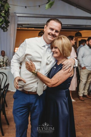 A groom hugs his mother during the reception at Burnham Grove
