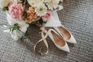 Bridal shoes sit beside the wedding bouquet