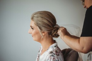 The brides sits while Iconix Bridal Salon fix her hair