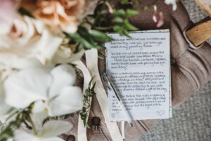 The brides wedding vows sit beside the wedding bouquet on a chair