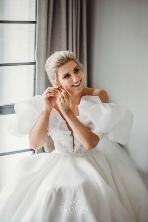 A bride puts on her earrings before the wedding