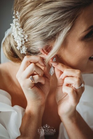 A bride puts on her earrings before the wedding