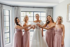 A bride toasts with her bridesmaids before heading out to their wedding ceremony