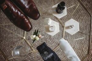 Grooms details sit on a glass table before the Camden wedding