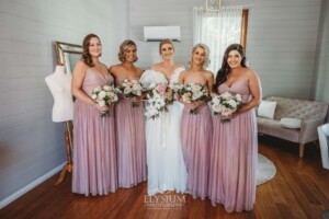 A bride stands with her bridesmaids before heading out to their wedding ceremony