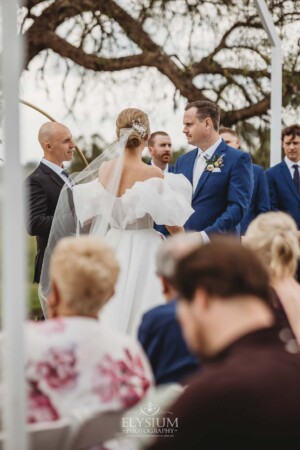 A couple exchange vows during their wedding ceremony surrounded by loved ones