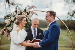 A bride and groom enjoy their wedding ceremony surrounded by loved ones
