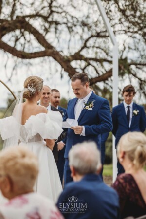 A couple exchange vows during their wedding ceremony surrounded by loved ones