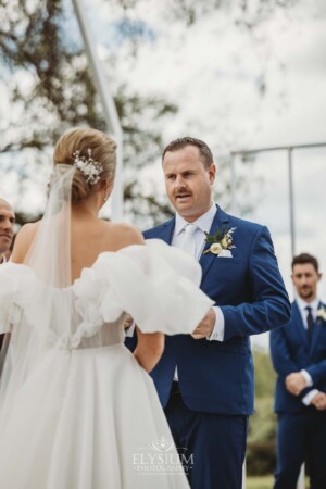 A couple exchange vows during their wedding ceremony surrounded by loved ones