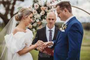 A couple exchange rings during their wedding ceremony at Burnham Grove