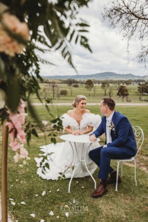 A bride and groom sign their wedding certificate during the ceremony