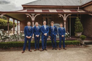 Groomsmen stand in front of the Burnham Grove homestead