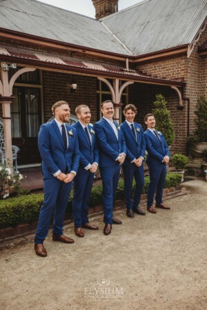 Groomsmen stand in front of the Burnham Grove homestead