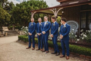Groomsmen stand in the driveway of their Camden wedding venue