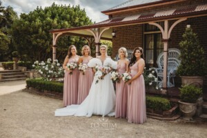 Bridal party pose for photos in front of the Burnham Grove homestead