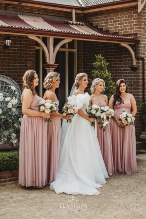 Bridal party pose for photos in front of the Burnham Grove homestead