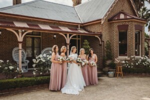 Bridal party stand in front of the Burnham Grove homestead