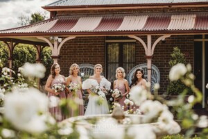 Bridal party stand in front of the Burnham Grove homestead rose garden