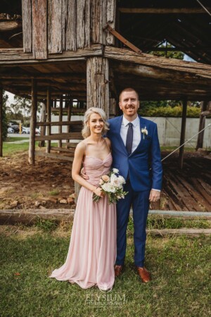 The bridal party posing for portraits in front of a rustic barn