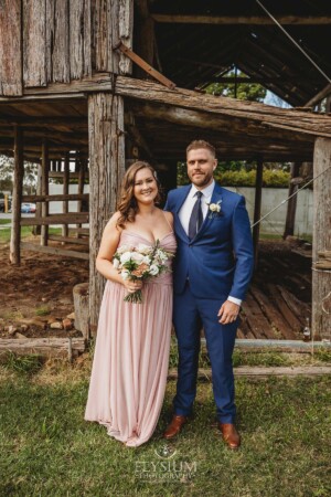 The bridal party posing for portraits in front of a rustic barn