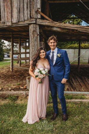 The bridal party posing for portraits in front of a rustic barn