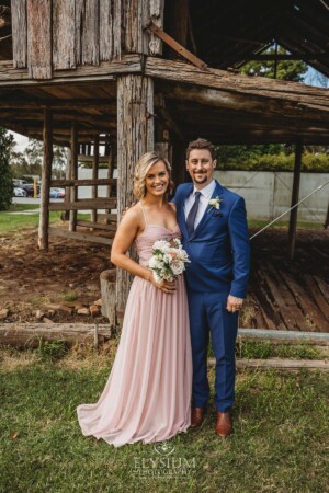 The bridal party posing for portraits in front of a rustic barn