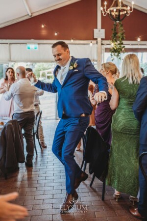 A groom dances his way into their wedding reception at Burnham Grove