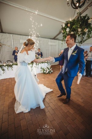 A bride and groom dance their way into the wedding reception surrounded by sparklers