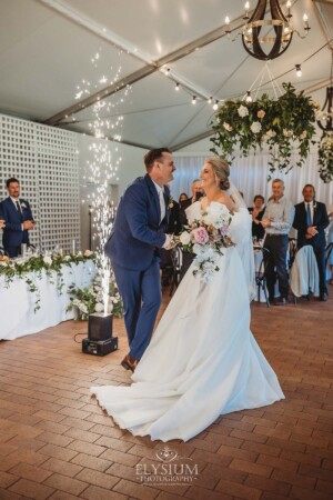 A bride and groom dance their way into the wedding reception surrounded by sparklers