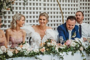 A bride and groom react to the wedding speeches during their reception