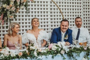 A bride and groom react to the wedding speeches during their reception