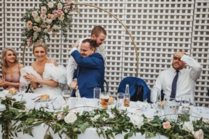 A groomsman hugs the groom after making his wedding speech