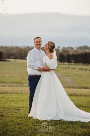 A groom laughs as he hugs his bride after their wedding