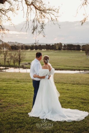 A couple look out over the hills at Burnham Grove as the sun sets on their wedding day