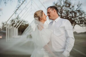 A couple stand hugging at sunset on their wedding day