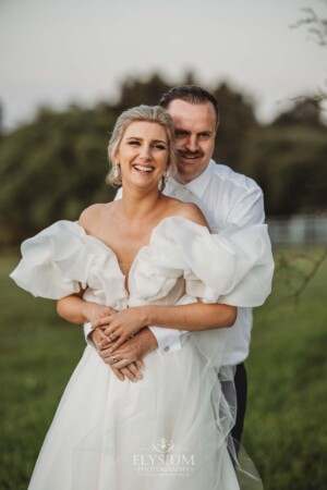 A groom holds his bride in his arms as the celebrate their wedding day