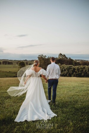 Newlyweds walk hand in hand along the ridge overlooking Burnham Grove at Camden