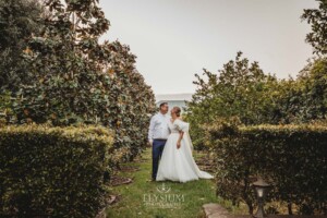 A couple stand amongst the trees after their wedding ceremony at Camden