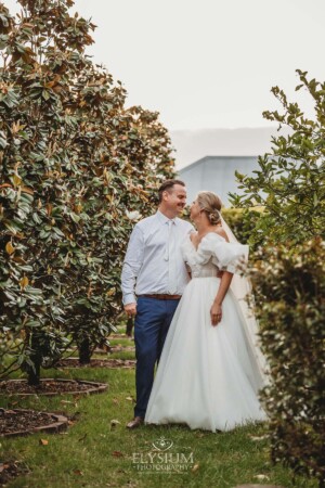 A newlywed couple stand in the orchard garden at Burnham Grove