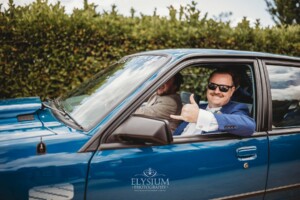 The groom arrives at his Camden wedding venue in a blue car